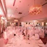 Dvorana za događanja s ružičastim osvjetljenjem, idealna za vjenčanja i svečane proslave.