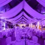 Uređena dvorana za evente s elegantnim ukrasima i rasvjetom.